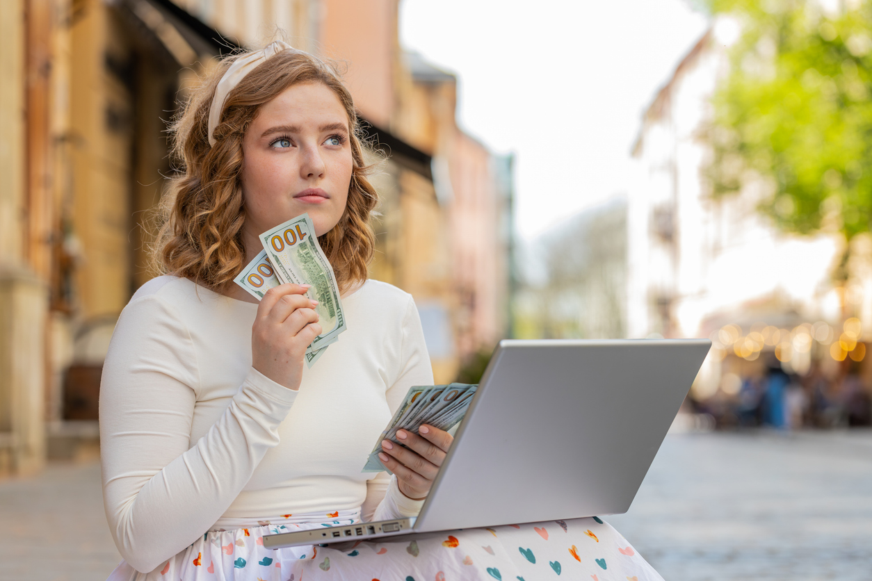 A woman holding foreign currency, symbolizing a U.S. expat catching up on unreported accounts through the Streamlined Domestic Offshore Procedures.